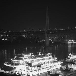 夜间千斯门大桥的渡轮码头，灯火辉煌。
The ferry terminals beneath Qiansi Gate Bridge glows brilliantly at night.